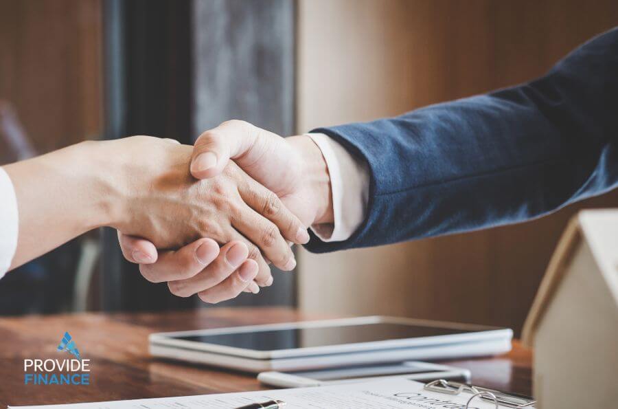 A client and agent shaking hands over a financing deal